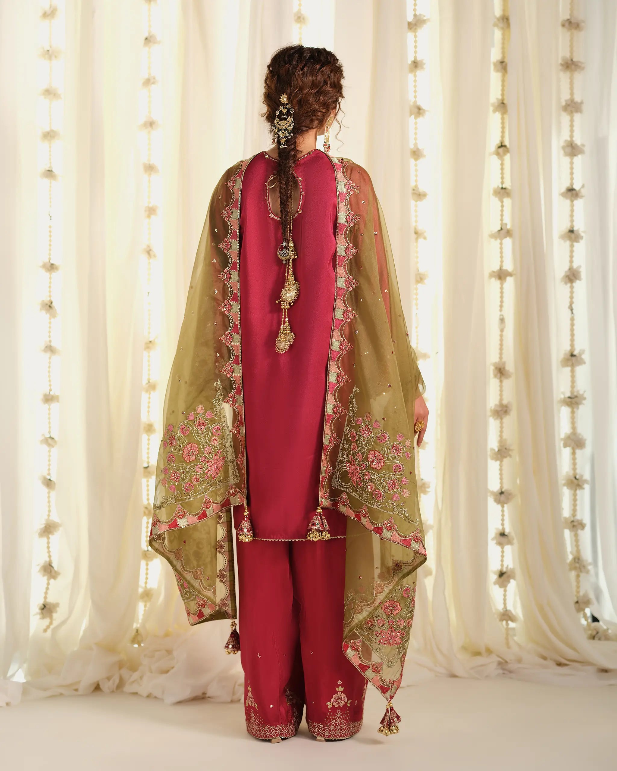 Back view of the 'Pehla Khat Chahat﻿' outfit, displaying the sheer olive green embroidered dupatta﻿'s drape and traditional hair accessories.