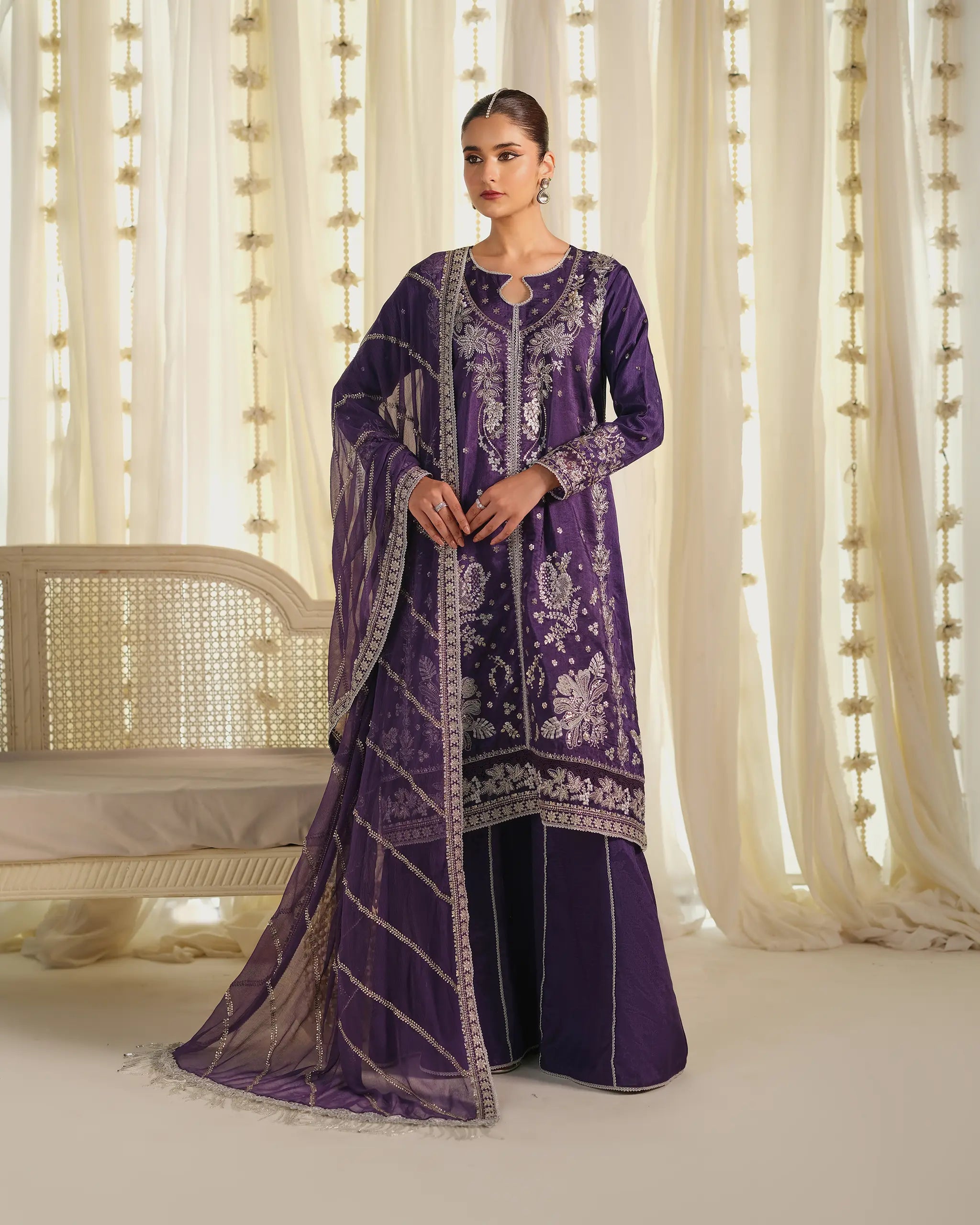 Detailed view of the sleeve of the purple 'Khumaar' suit, showing the elaborate silver floral embroidery and delicate hand jewelry.