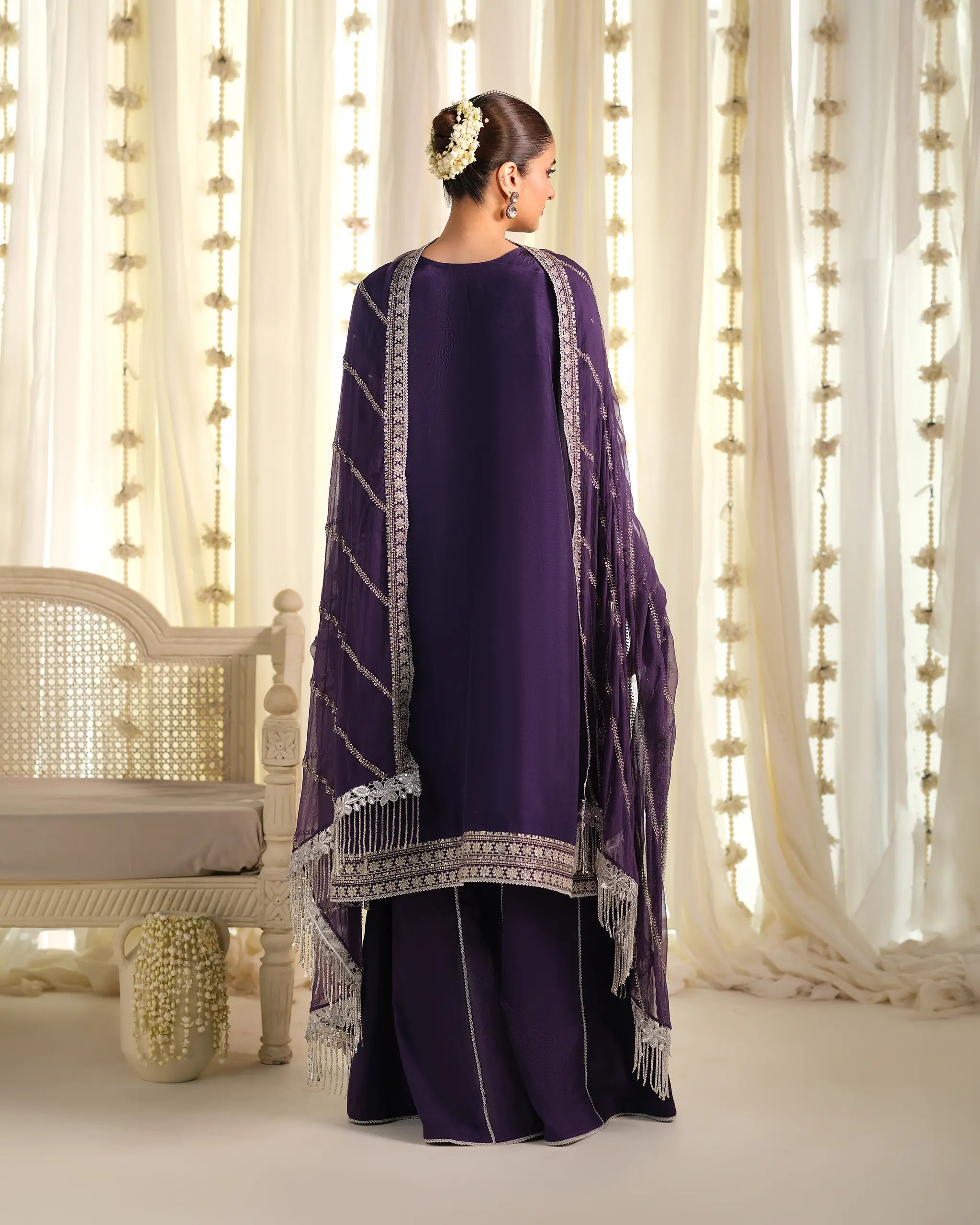 Back view of the 'Pehla Khat Khumaar﻿' outfit, showcasing the drape of the sheer purple 'dupatta﻿' with silver details and a traditional floral hair accessory.