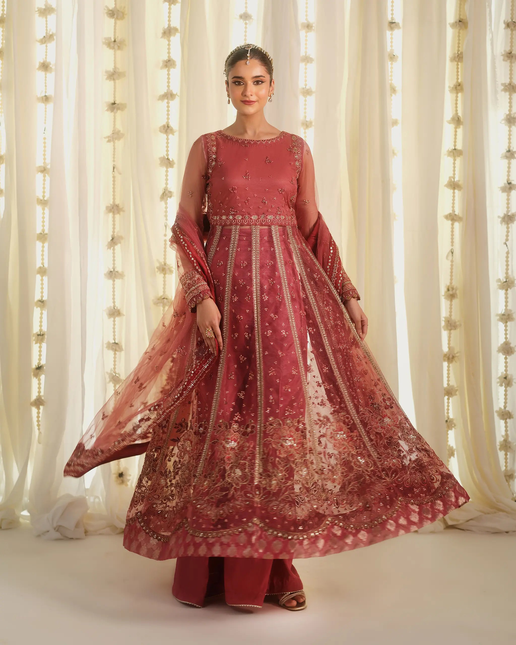 Model twirling in 'mohabbat', a dusty pink outfit from the 'Pehla Khat' collection, showcasing the fluid movement of the heavily embroidered sheer fabric.