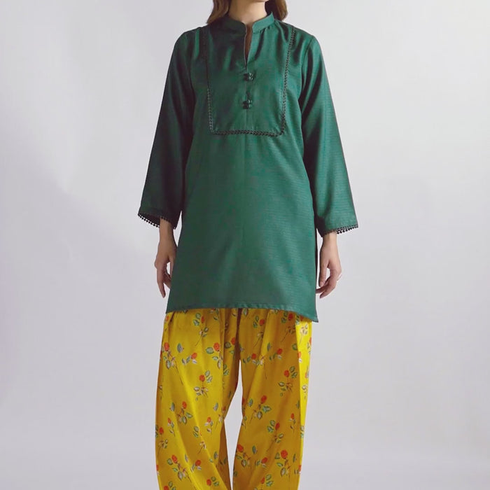 Sinoor's 'Nora' pret suit from the Winter Basic Collection. Features a dark green kurta paired with a vibrant yellow floral shalwar. Ready-to-wear for women.