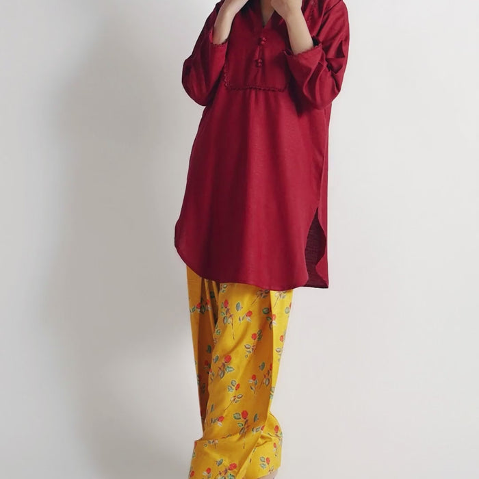 Sinoor's 'Nora' pret suit from the Winter Basic Collection, pairing a red kurta with a yellow floral shalwar. Stylish ready-to-wear for women.