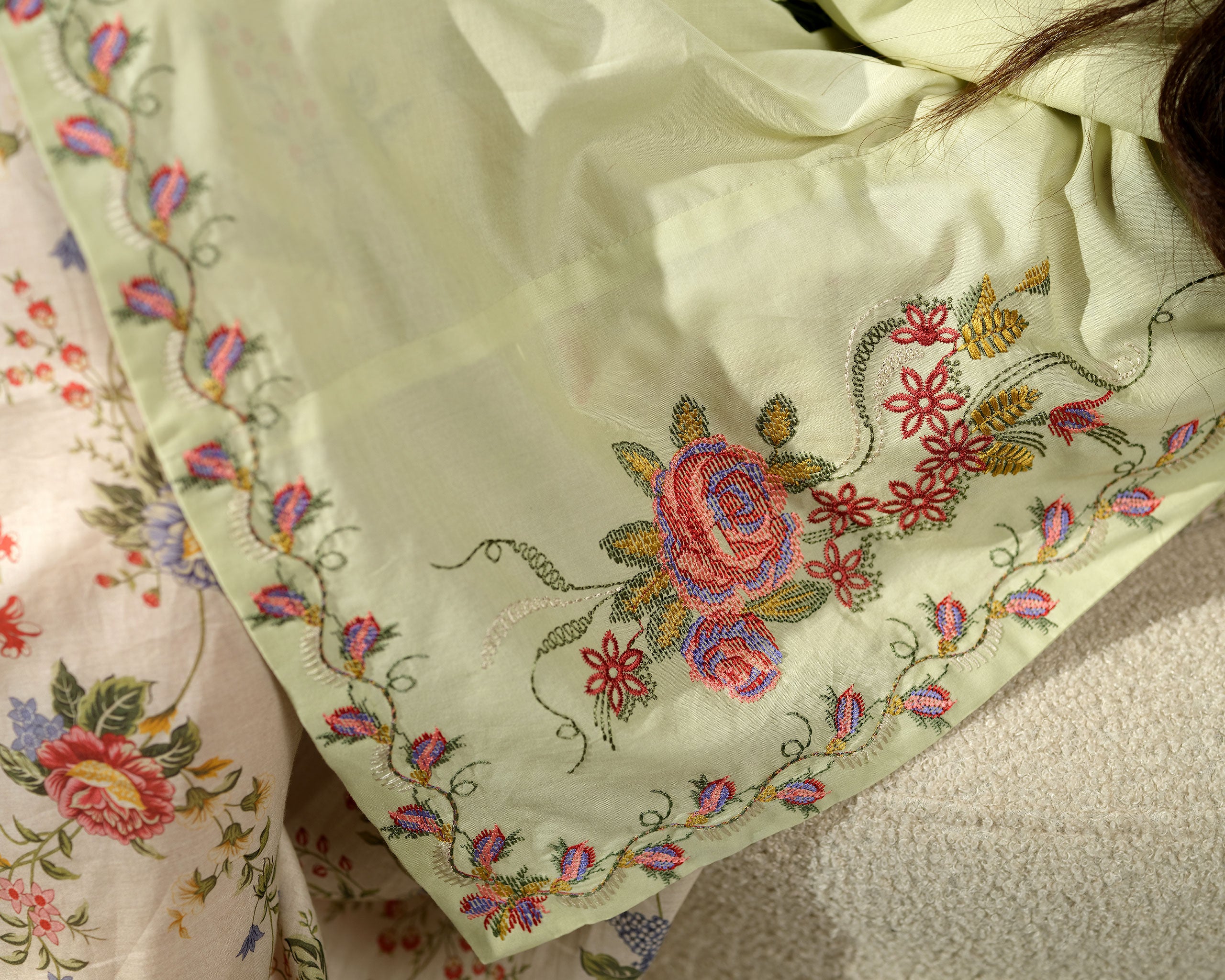 Sinoor Shop pret casual 2025 Zohra Mint Green outfit. A woman stands looking to the side, wearing a light mint green kurta with floral embroidery and patterned bell sleeves, paired with matching floral print trousers. She has long, dark wavy hair and is wearing light-colored flat sandals. Full standing shot, soft studio lighting with shadows.