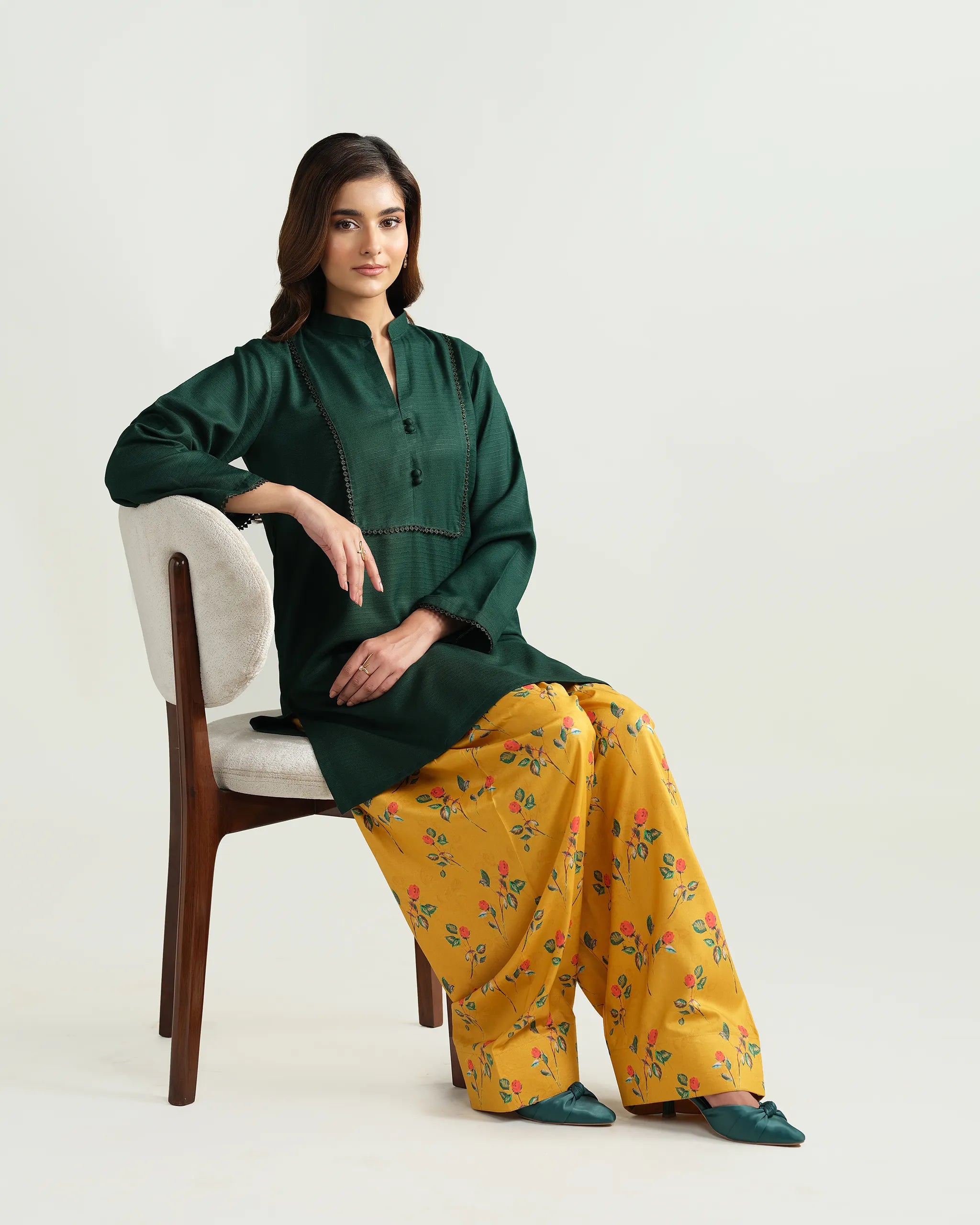 Sinoor's 'Nora' pret suit from the Winter Basic Collection. Features a dark green kurta paired with a vibrant yellow floral shalwar. Ready-to-wear for women.