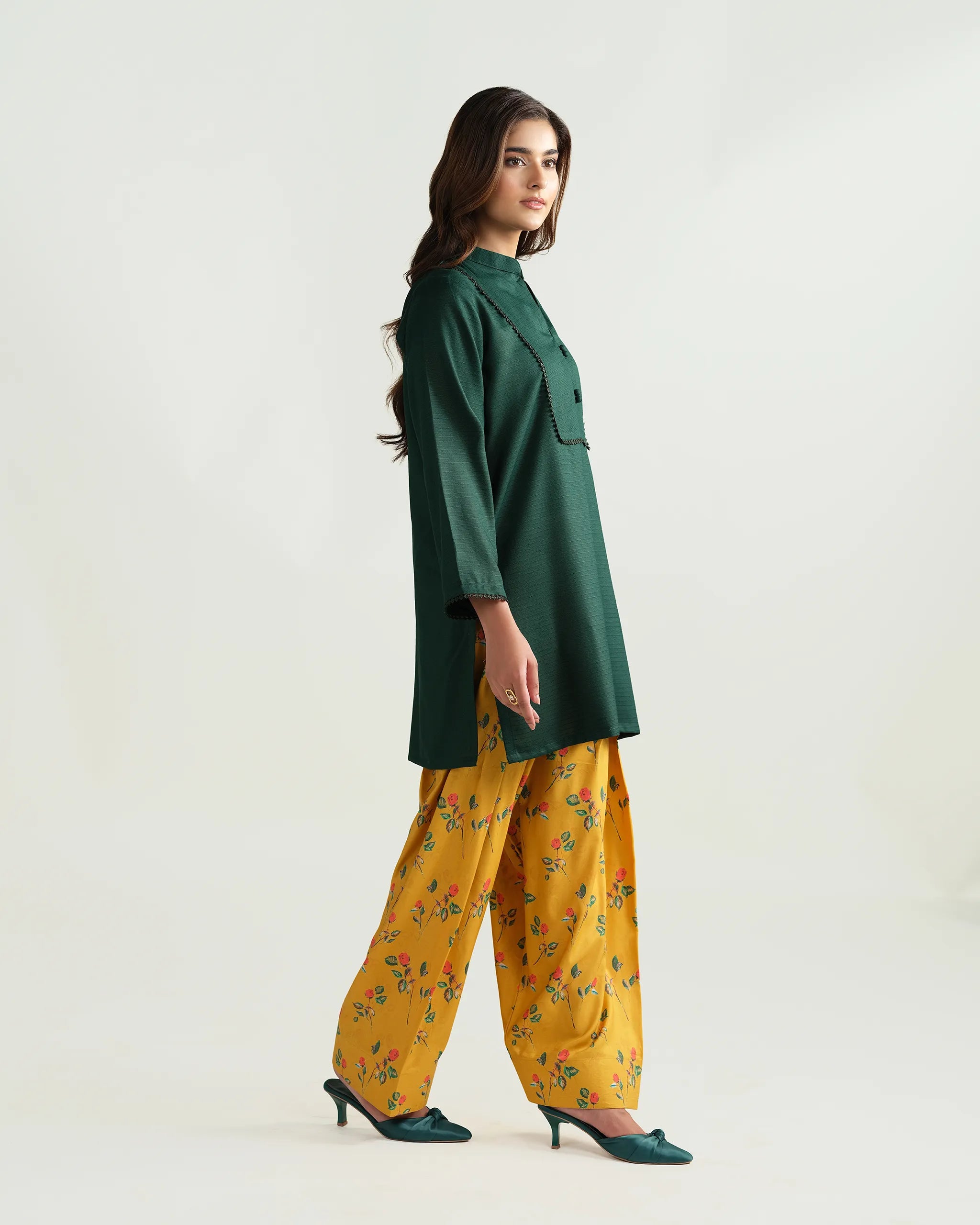 Sinoor's 'Nora' pret suit from the Winter Basic Collection. Features a dark green kurta paired with a vibrant yellow floral shalwar. Ready-to-wear for women.