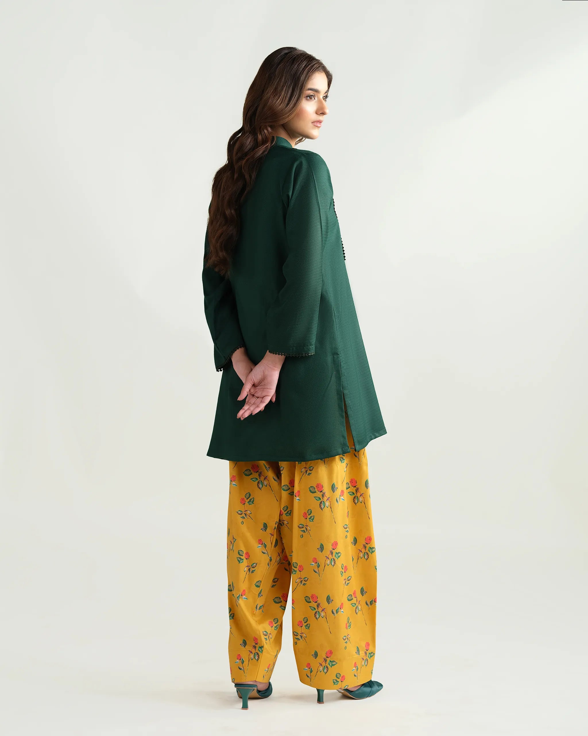 Sinoor's 'Nora' pret suit from the Winter Basic Collection. Features a dark green kurta paired with a vibrant yellow floral shalwar. Ready-to-wear for women.