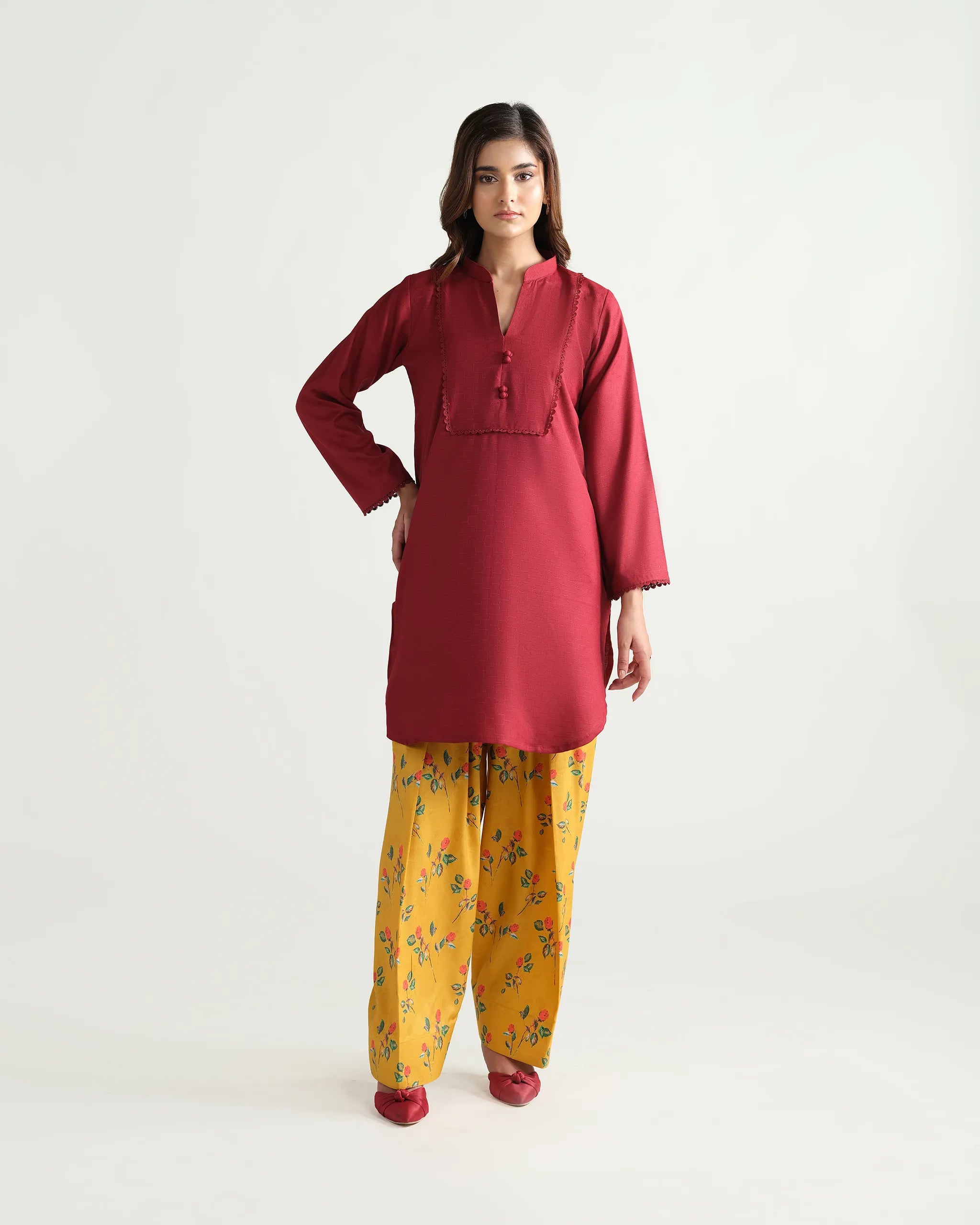 Sinoor's 'Nora' pret suit from the Winter Basic Collection, pairing a red kurta with a yellow floral shalwar. Stylish ready-to-wear for women.