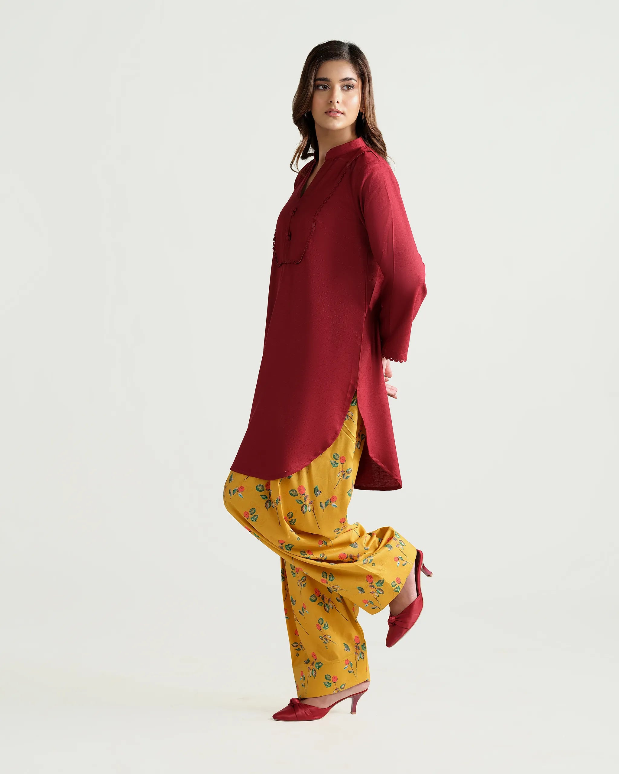 Sinoor's 'Nora' pret suit from the Winter Basic Collection, pairing a red kurta with a yellow floral shalwar. Stylish ready-to-wear for women.